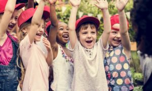 OST, youth summer learning grants: happy children raising hands outside